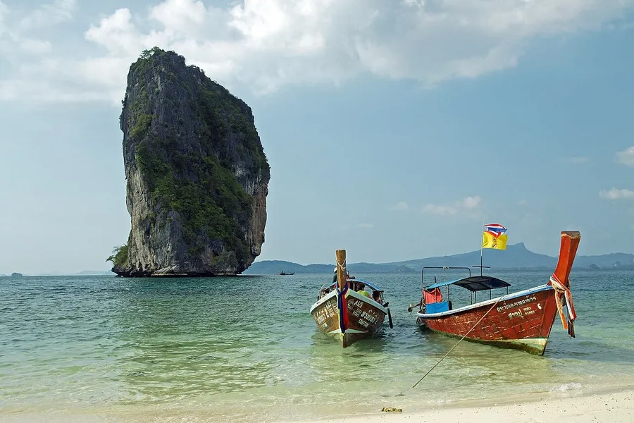 Playa de Koh Poda con embarcaciones y roca caliza frente a la costa