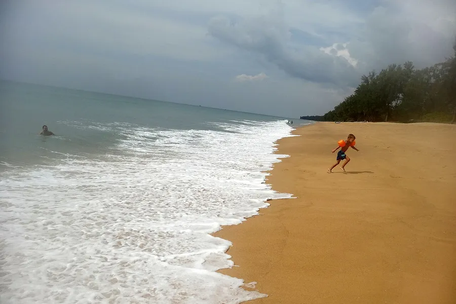 Arena y línea de costa de Mai Khao Beach en el norte de Phuket