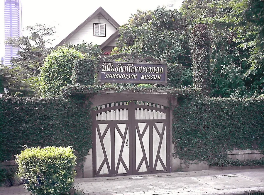 Entrada de madera y vegetación del Museo Bangkokian
