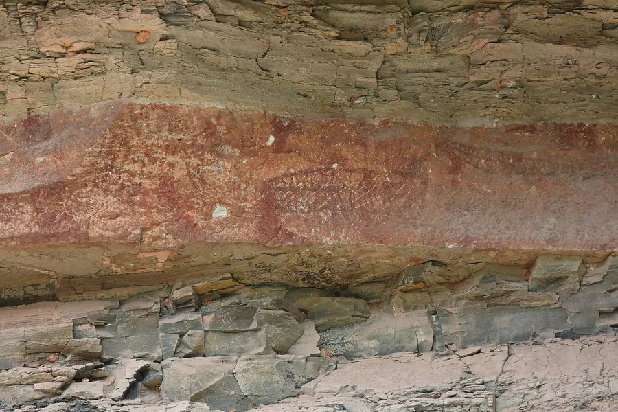 Pinturas rupestres rojizas con figuras de peces en la pared de arenisca del acantilado de Pha Taem