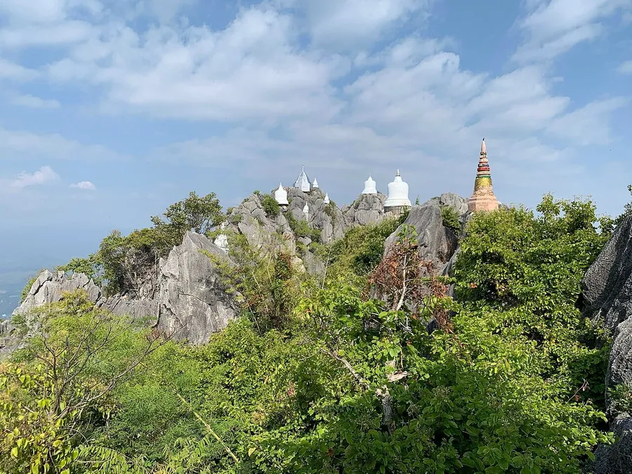 Pagodas blancas y doradas sobre las crestas de Wat Chaloem Phra Kiat de Lampang
