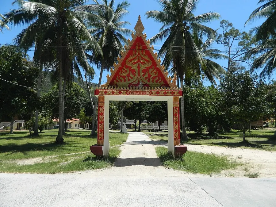 Puerta de entrada de Wat Maduea Wan entre palmeras en Koh Phangan