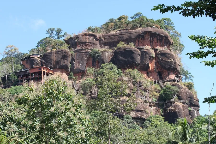 El peñón de arenisca rojiza de Wat Phu Tok, con las pasarelas y plataformas de madera adosadas a la roca